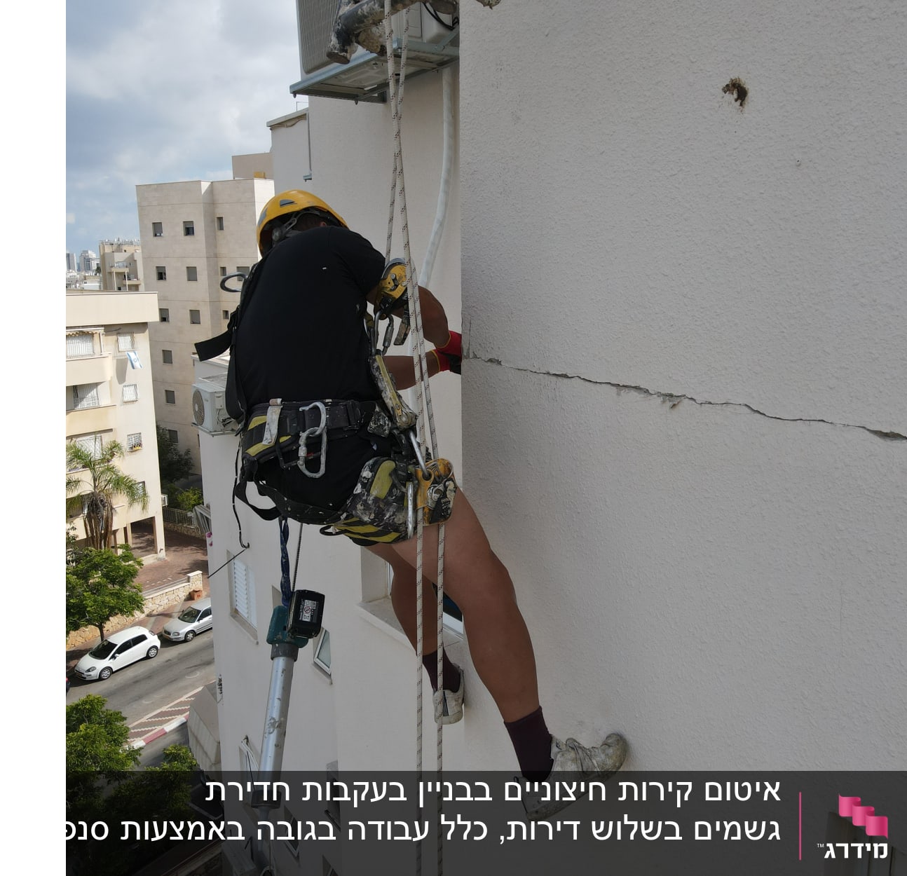 אדם על חבל אוטם סדק בקיר חיצוני